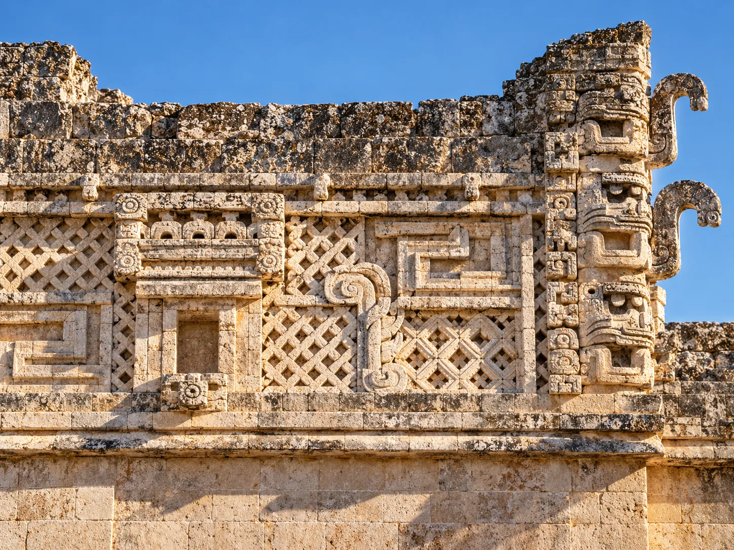 Friso de mosaico de piedra estilo Puuc en Uxmal con celosías, grecas y mascarones de Chaac de nariz curva